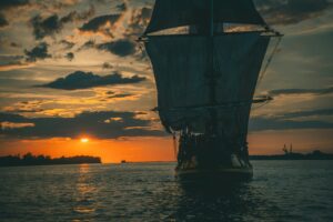 A ship sailing out at dusk.